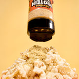 Protein powder being sprinkled onto popcorn with a yellow background