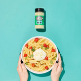 Bowl of pasta with a protein supplement jar on a teal background